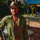 Juan Cortez stands in a campground on a sunny day in Far Cry 6.